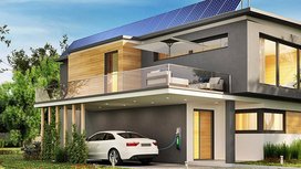 Ein modernes Haus mit einer Photovoltaikanlage und einem Elektroauto das geladen wird